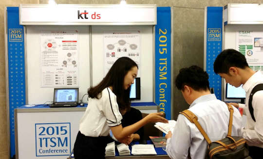 KT DS SW기술연구소 직원이 '2015 ITSM 컨퍼런스' 내에 설치된 홍보 부스에서 고객에게 '오픈소스 토탈 서비스'를 소개하고 있다.  KT DS 제공